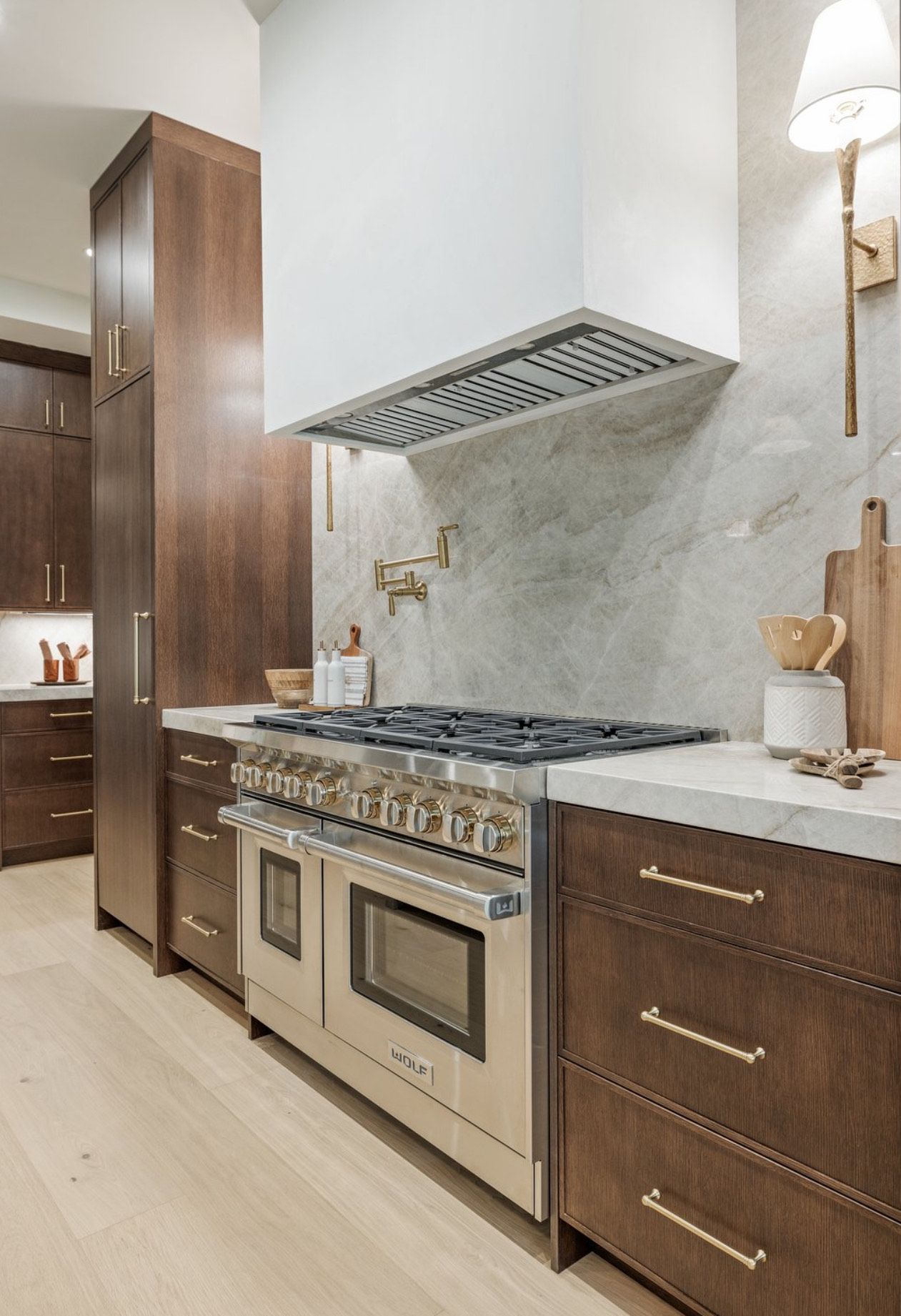 Stainless steel range in a modern kitchen with dark wood cabinets and white countertops.