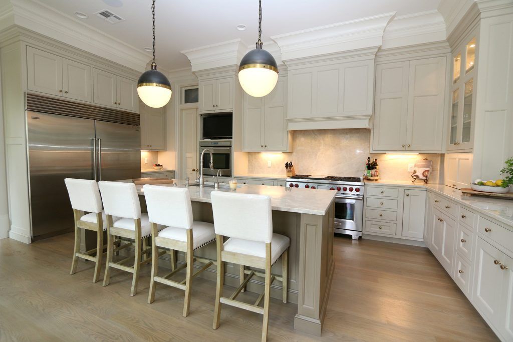 Elegant kitchen with beige cabinets, large island, stainless steel appliances, and pendant lights.