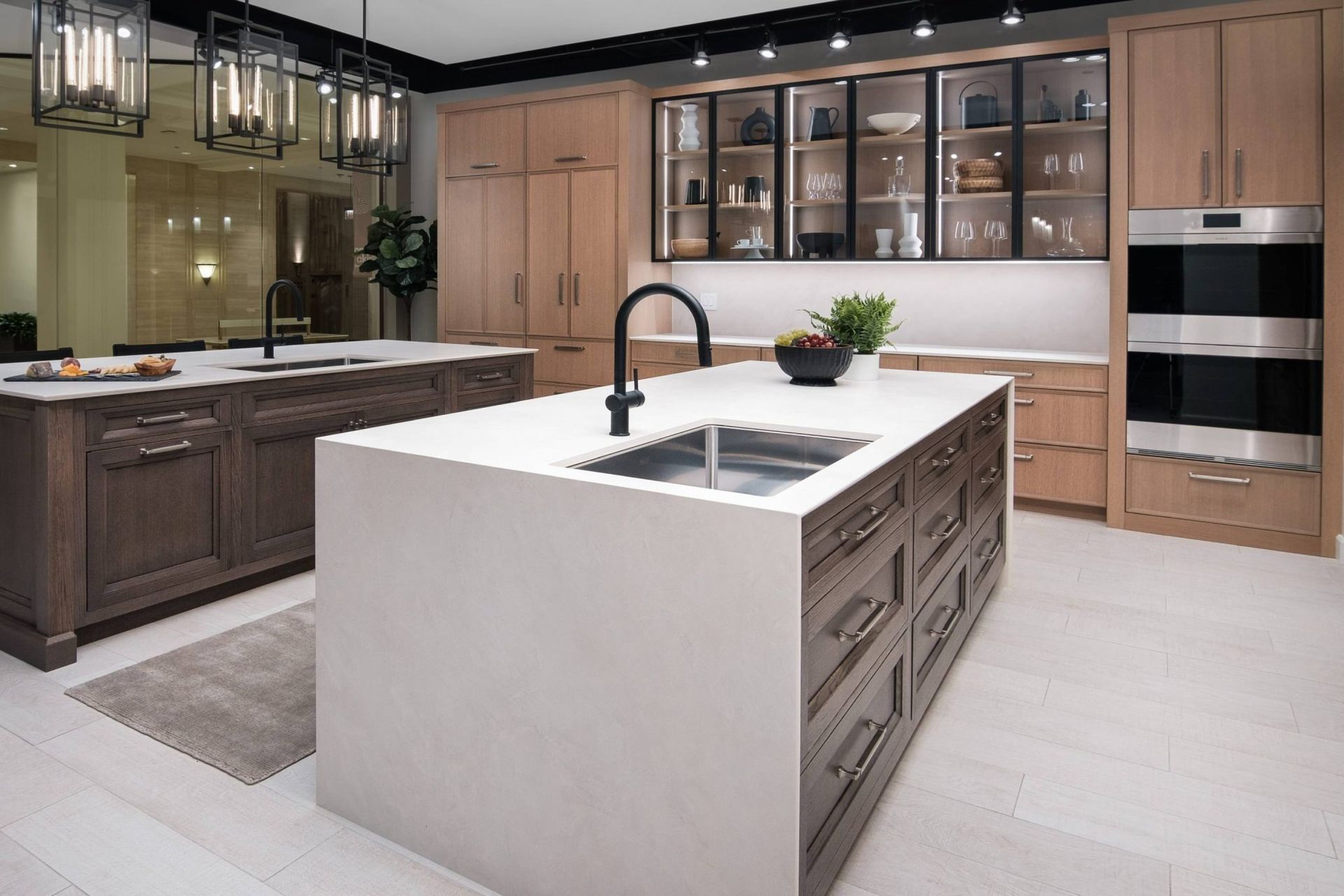 Kitchen with brown cabinets, stainless steel appliances, granite countertops, and wood flooring; stools at the breakfast bar.