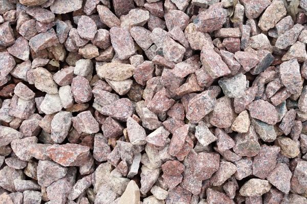 A pile of pink gravel is sitting on the ground.