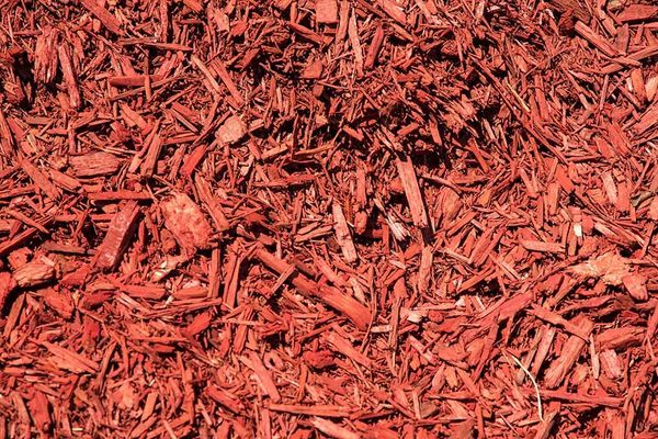 A pile of red mulch is sitting on the ground.