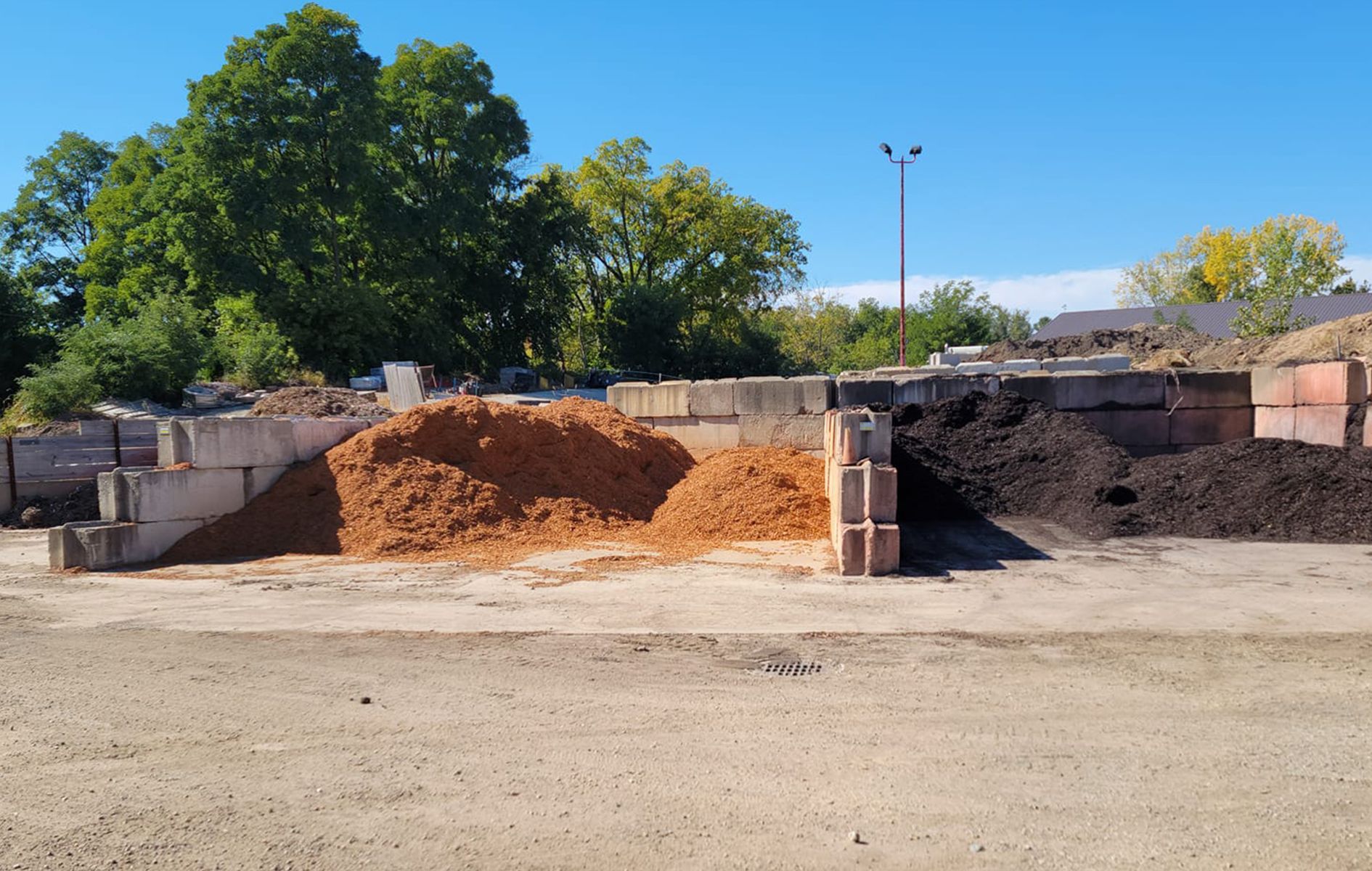 Mulch piles in various colors at a landscaping supply yard.