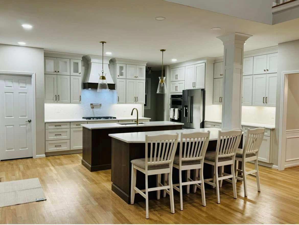 A kitchen with a large island and chairs in it