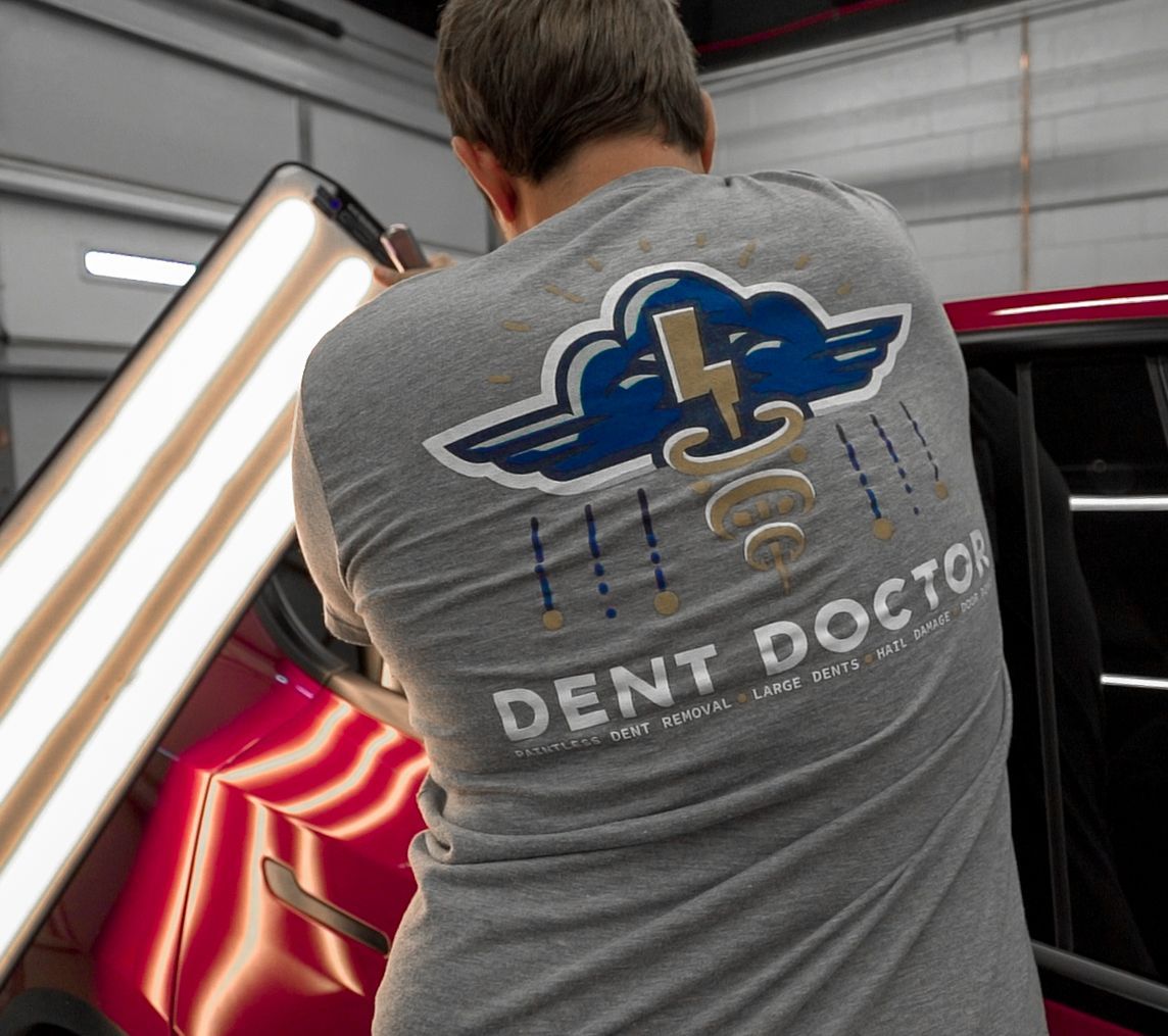 Person repairing a red car, wearing a 