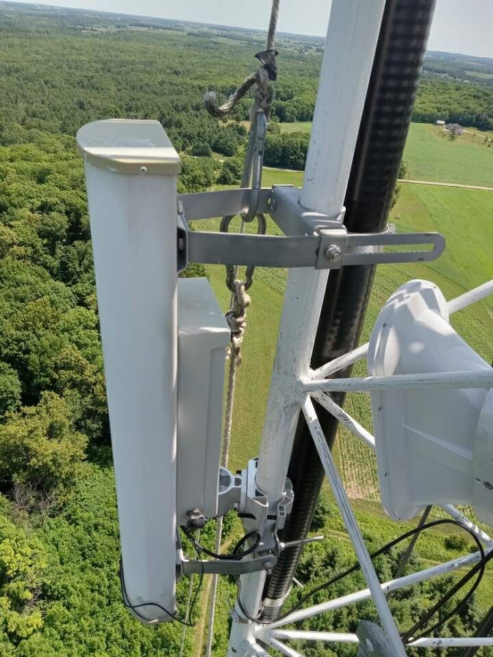 An aerial view of a tower with a satellite dish attached to it.