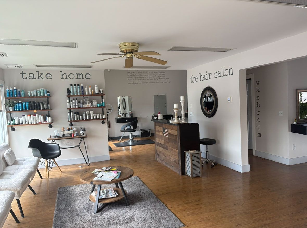 Hair salon interior with product shelves, seating area, and styling stations