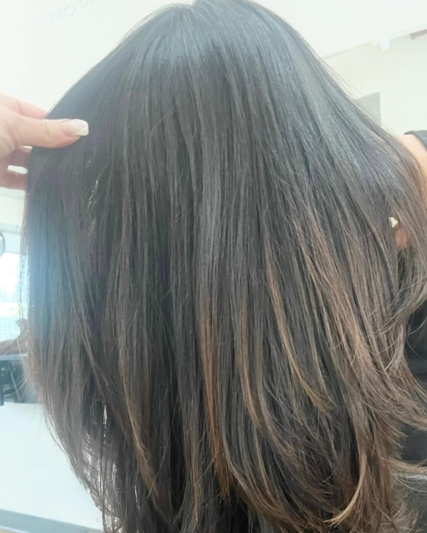 Dark brown hair with subtle highlights, being held up.