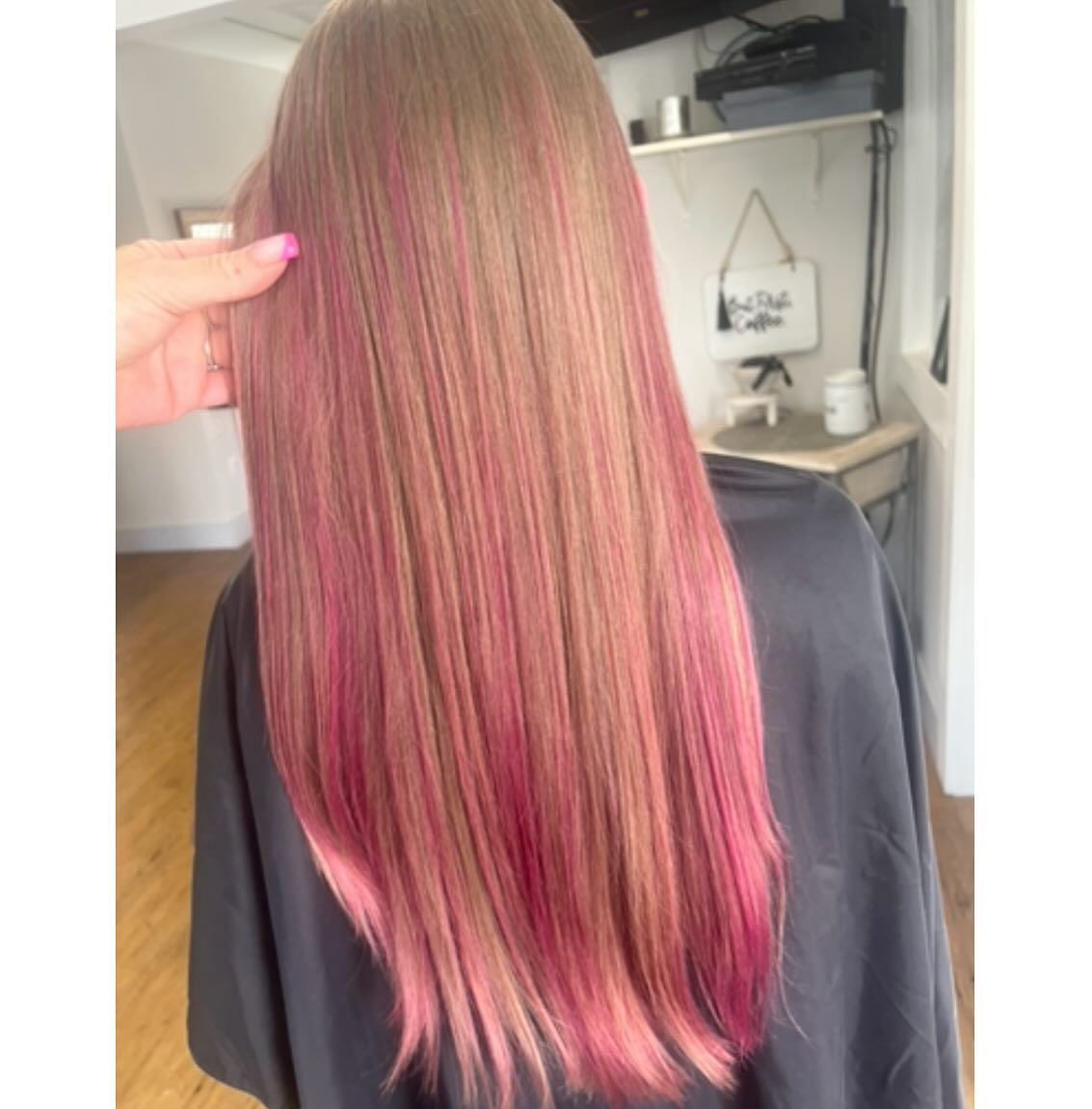 Woman's long, straight hair with a muted blonde base and bright pink highlights/lowlights.