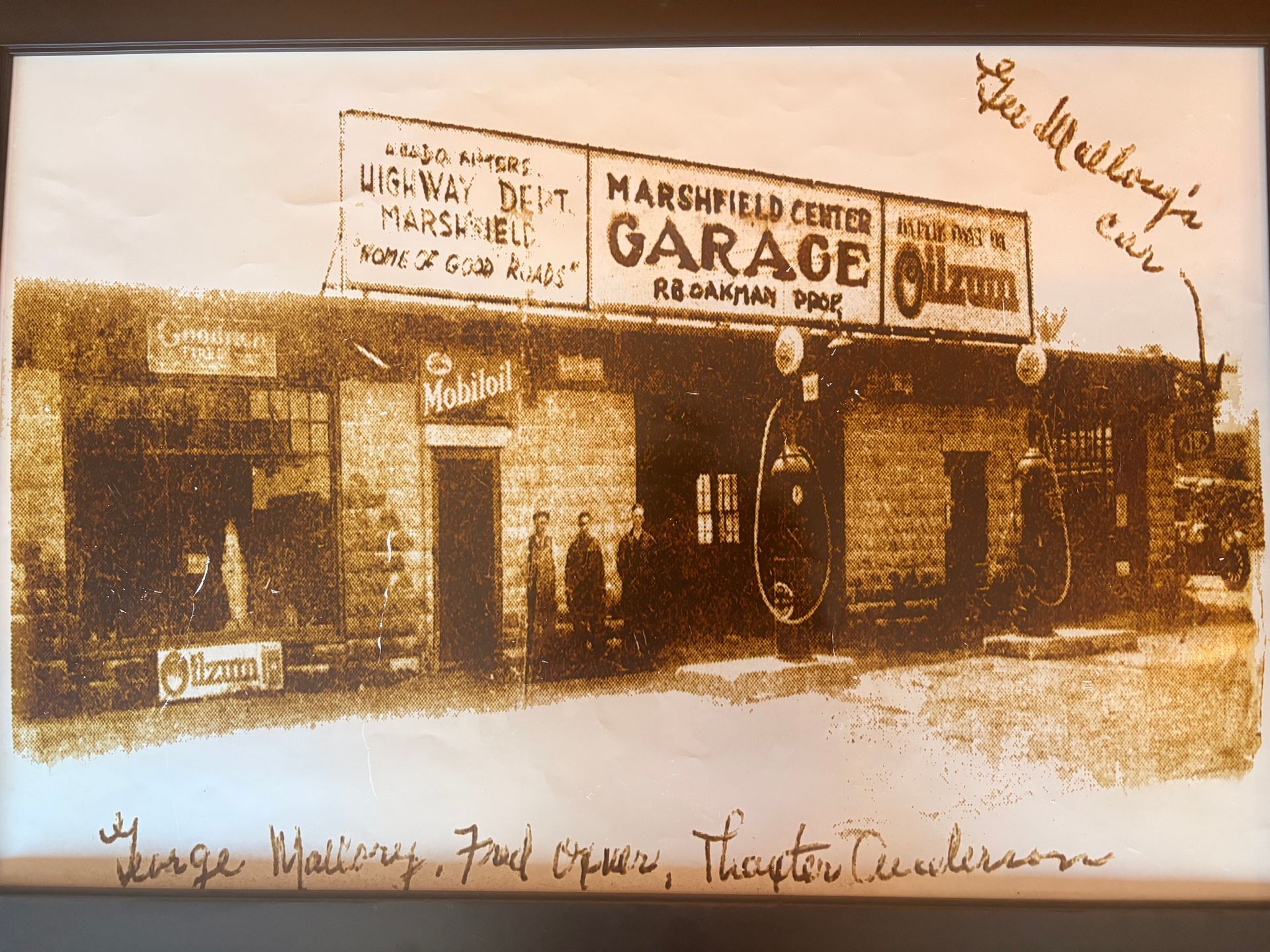 Vintage photo of Marshfield Center Garage, with people standing in front. Store sign and old cars are visible.