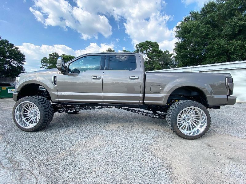 A ford f250 pickup truck is parked on a gravel road.