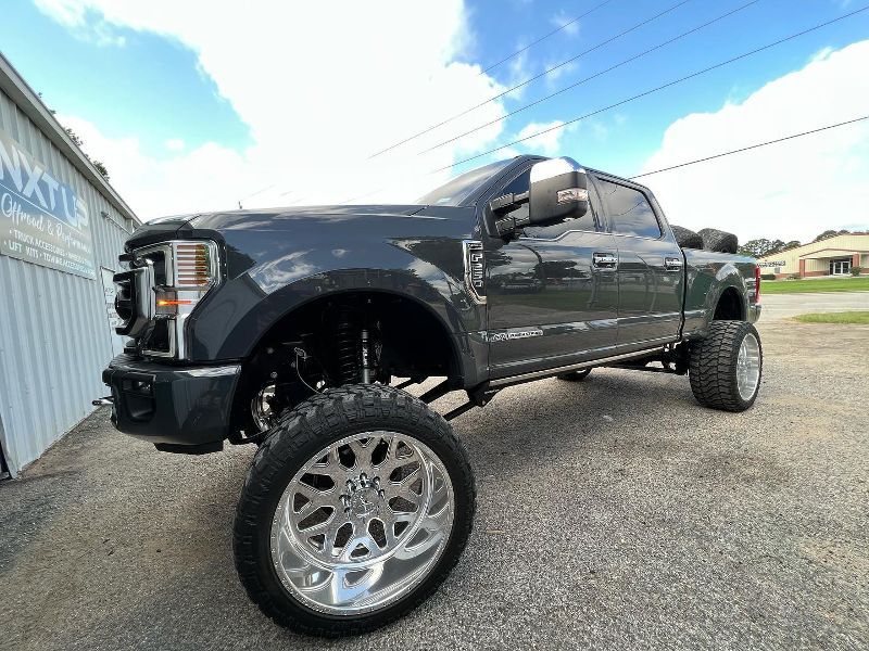 A black pickup truck with chrome wheels is parked in front of a building.