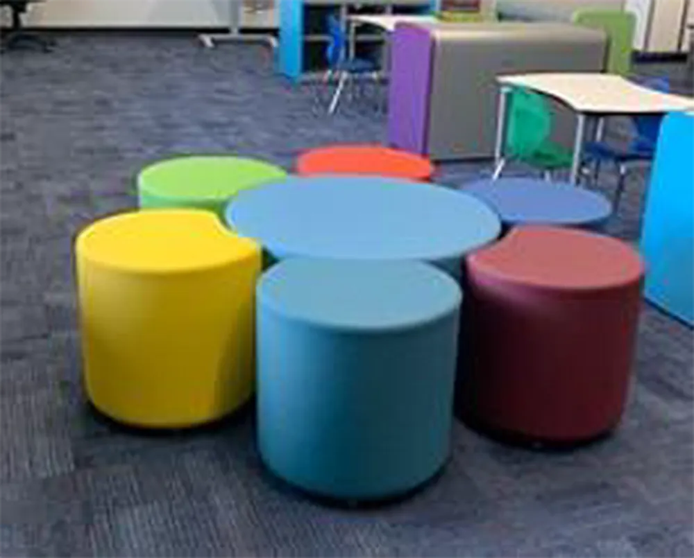 Colorful round stools and tables in a classroom setting.