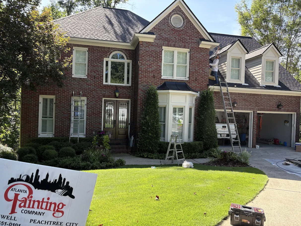 Brick house with a front lawn, driveway, and an Atlanta Painting Company lawn sign in front