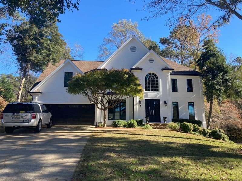 A white house with a car parked in front of it