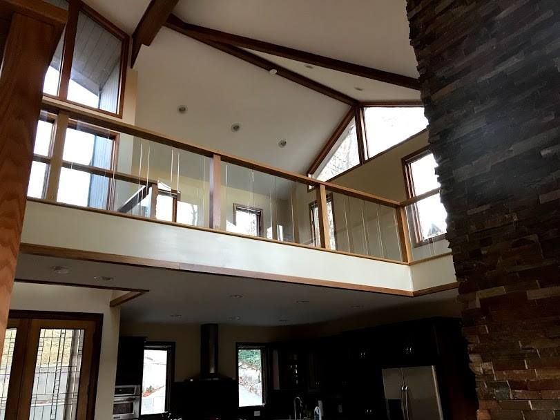 A house with a balcony and a brick fireplace