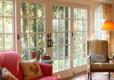 A living room with french doors and a red couch