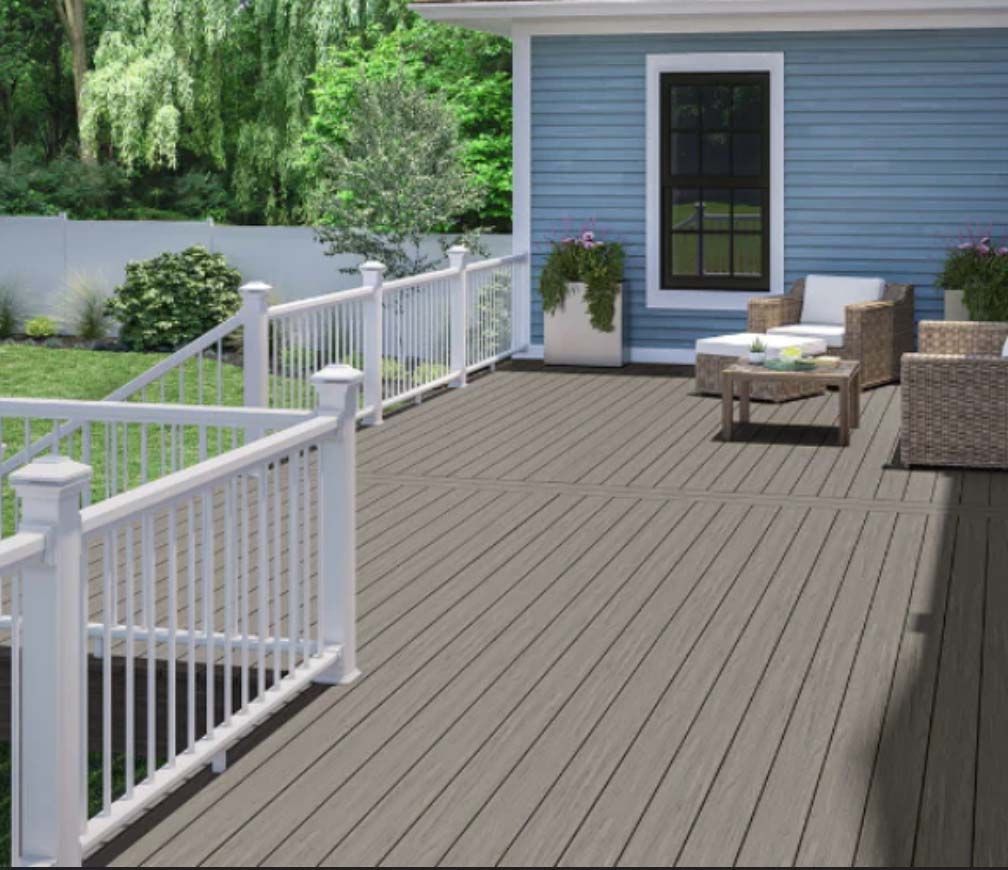A wooden deck with a white railing and a blue house in the background.