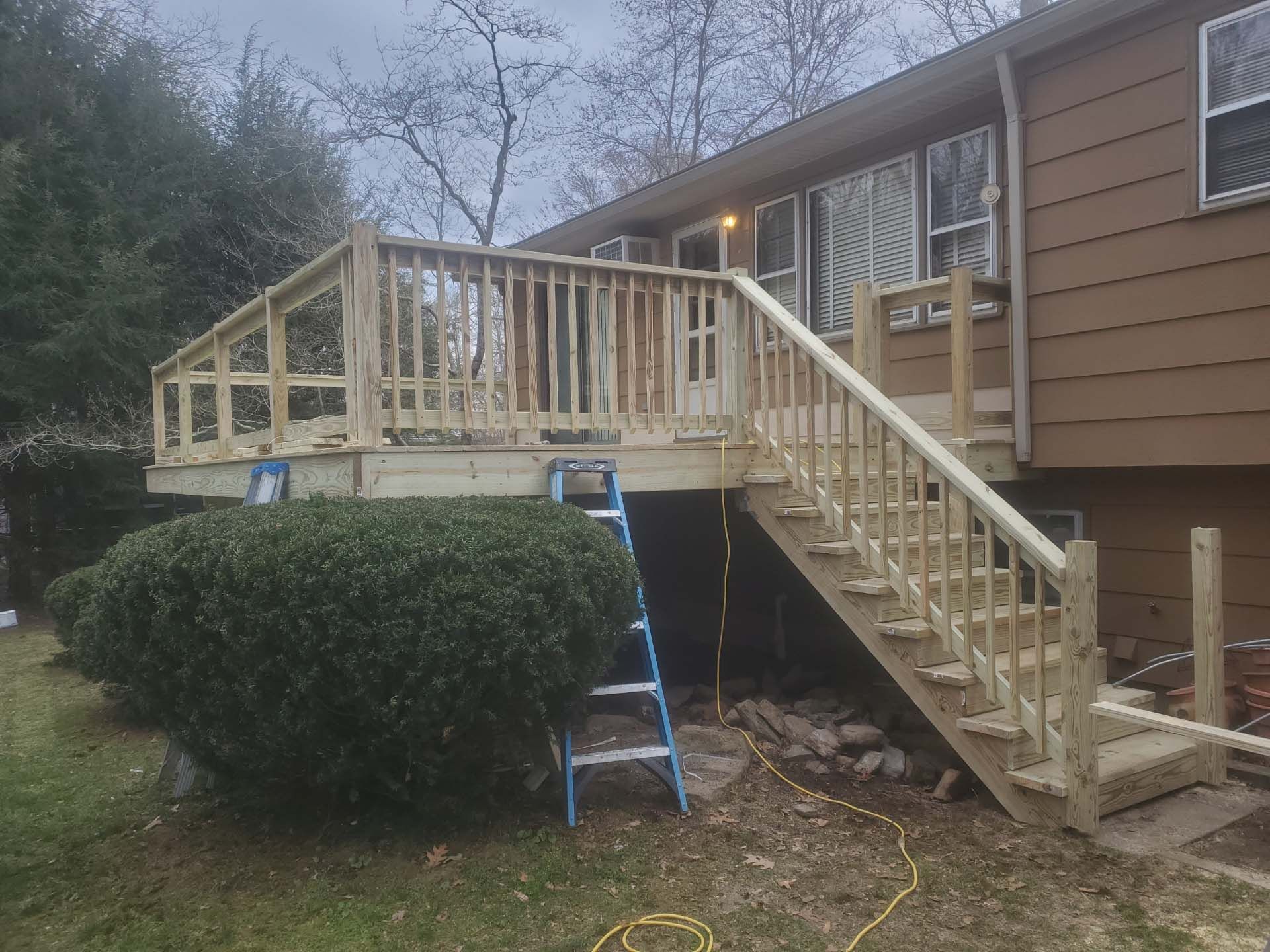 A wooden deck is being built on the side of a house.