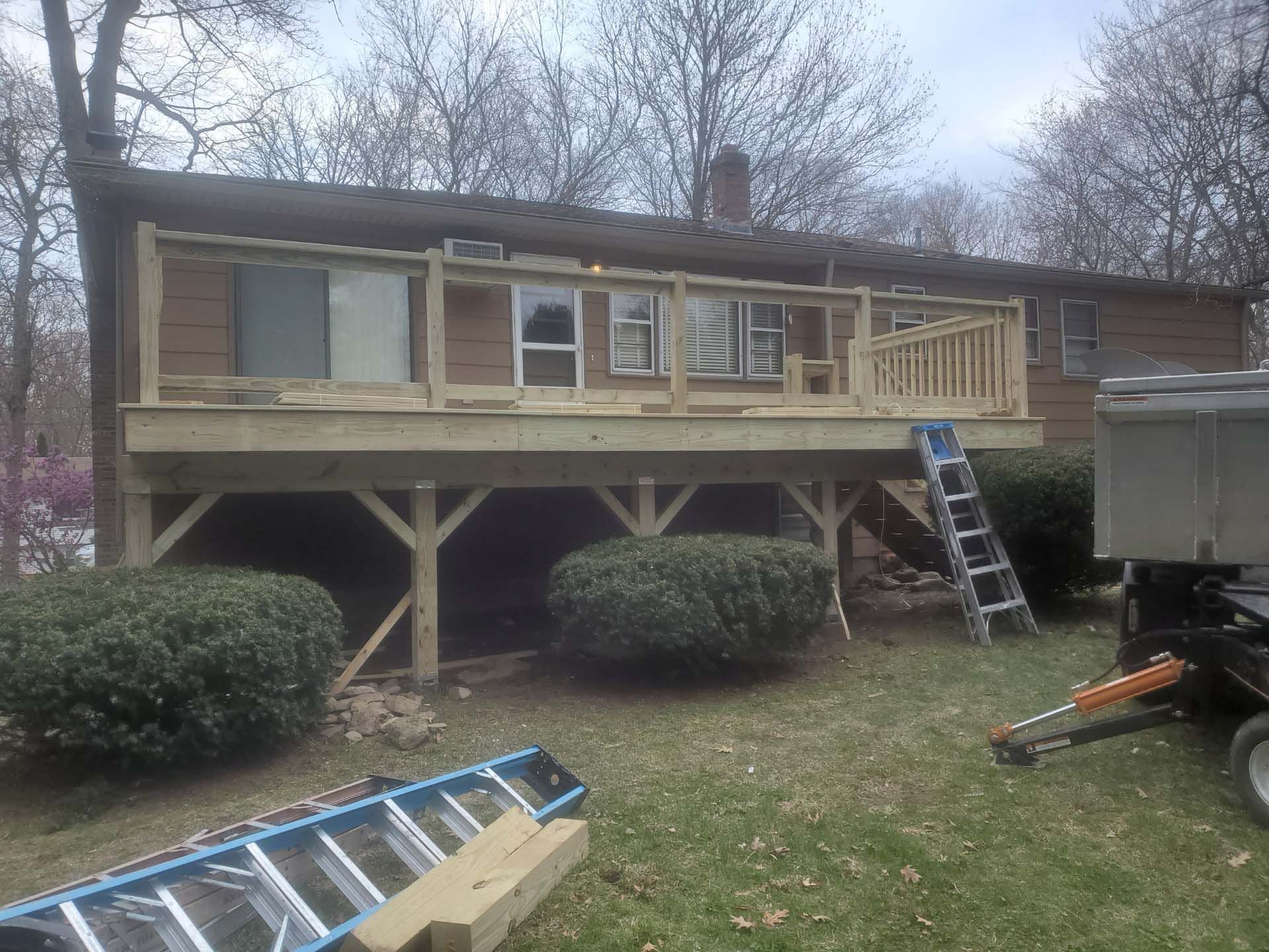 A wooden deck is being built in the backyard of a house