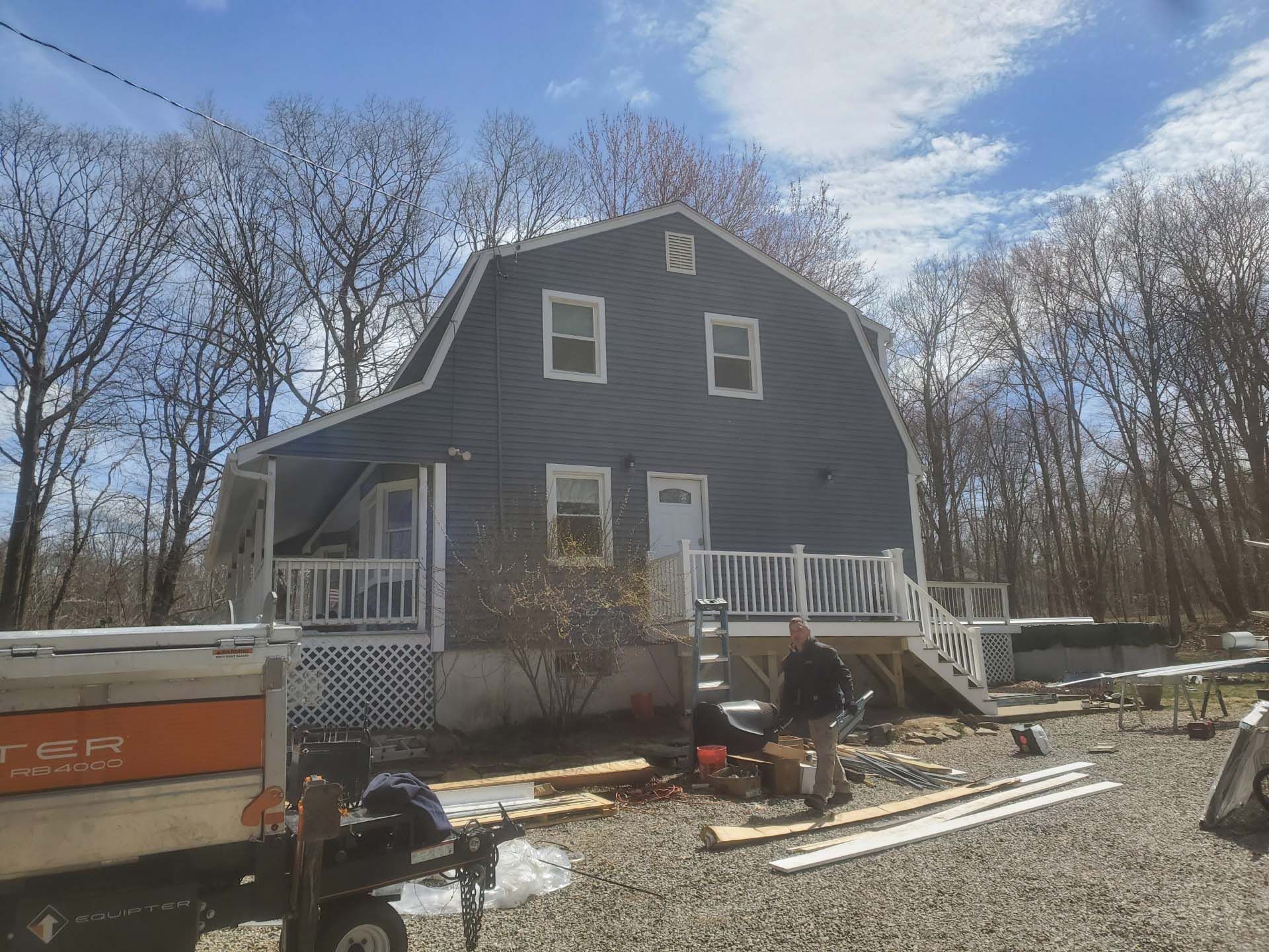 A large house with a barn shaped roof is being remodeled.