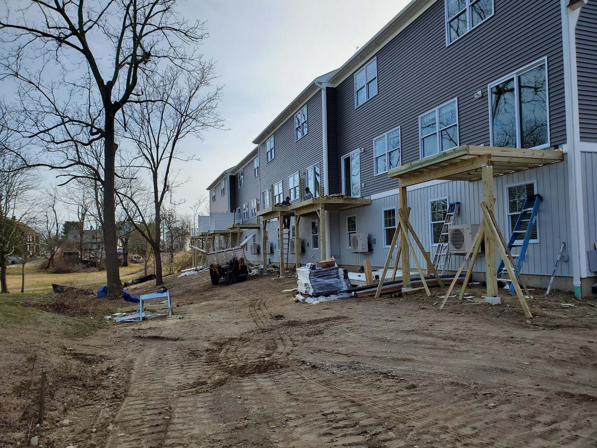 A building under construction with a wooden deck in front of it.
