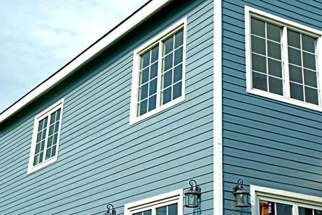 A blue house with white windows and lanterns on the side