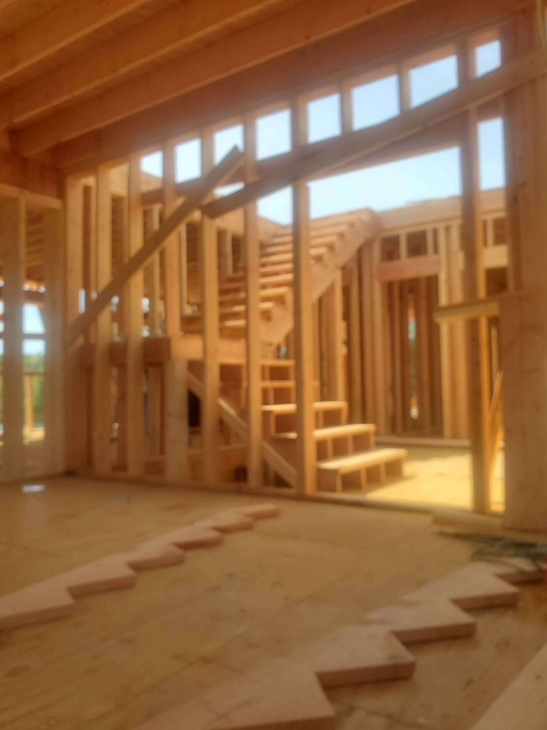 A wooden house under construction with stairs and windows