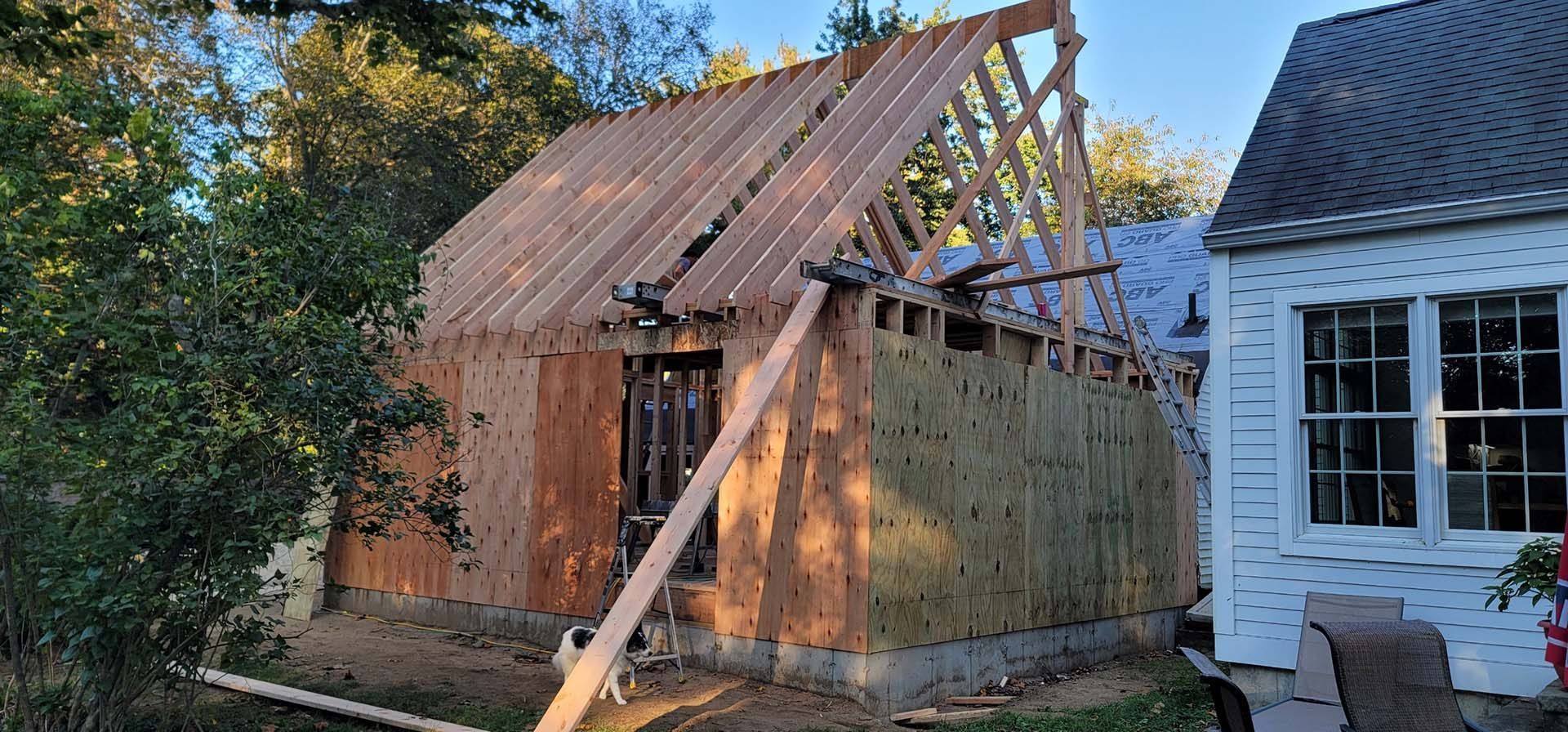 A wooden structure is being built next to a house.