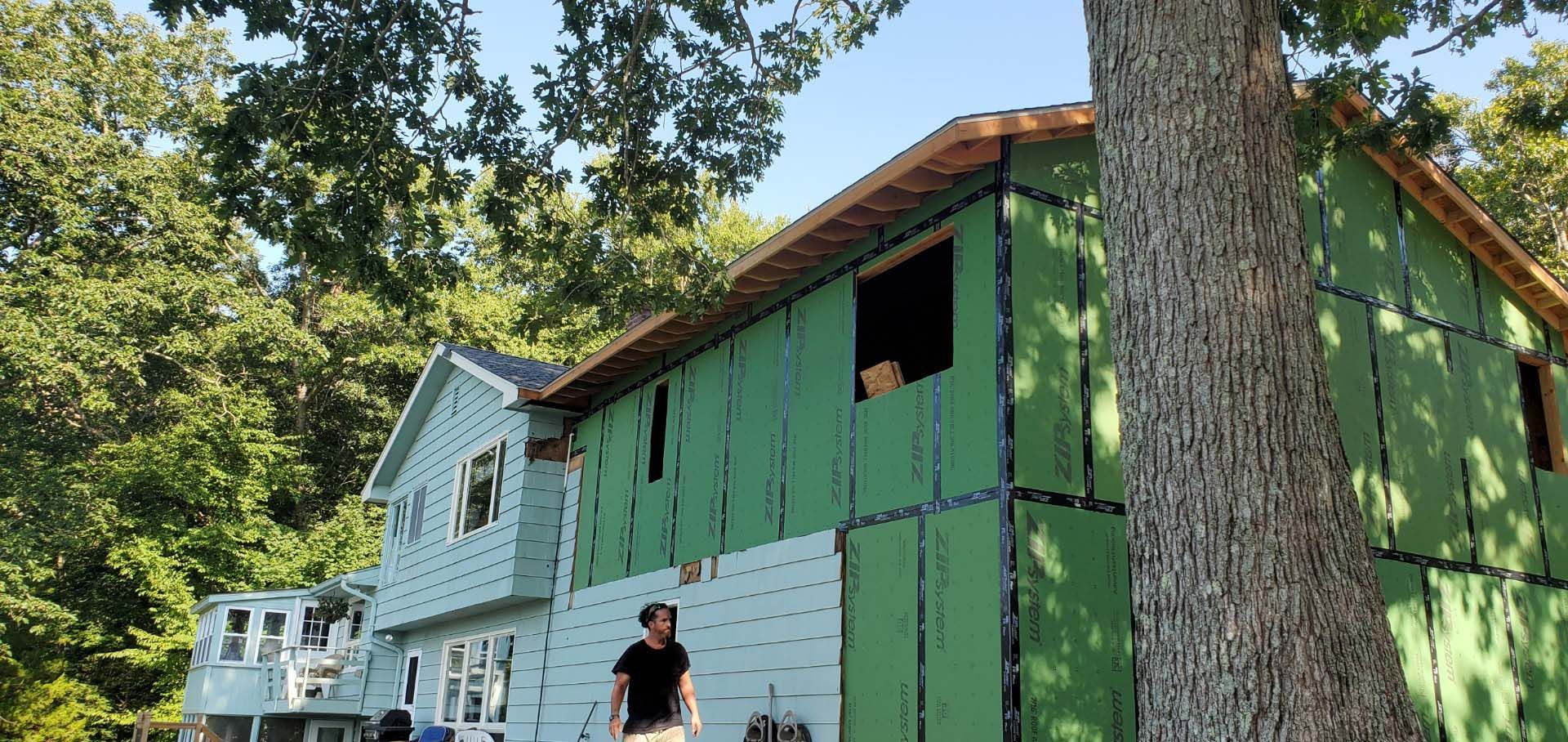 A man is standing in front of a house that is being built.