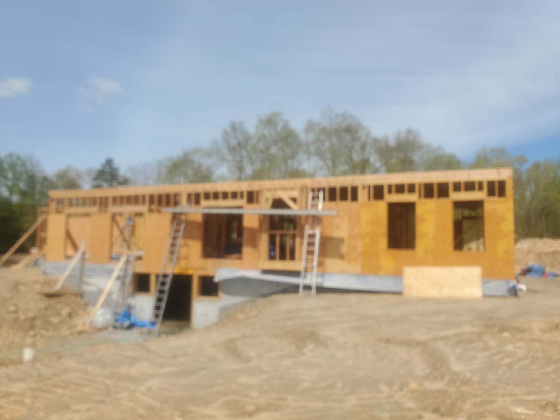 A house is being built in the middle of a dirt field.
