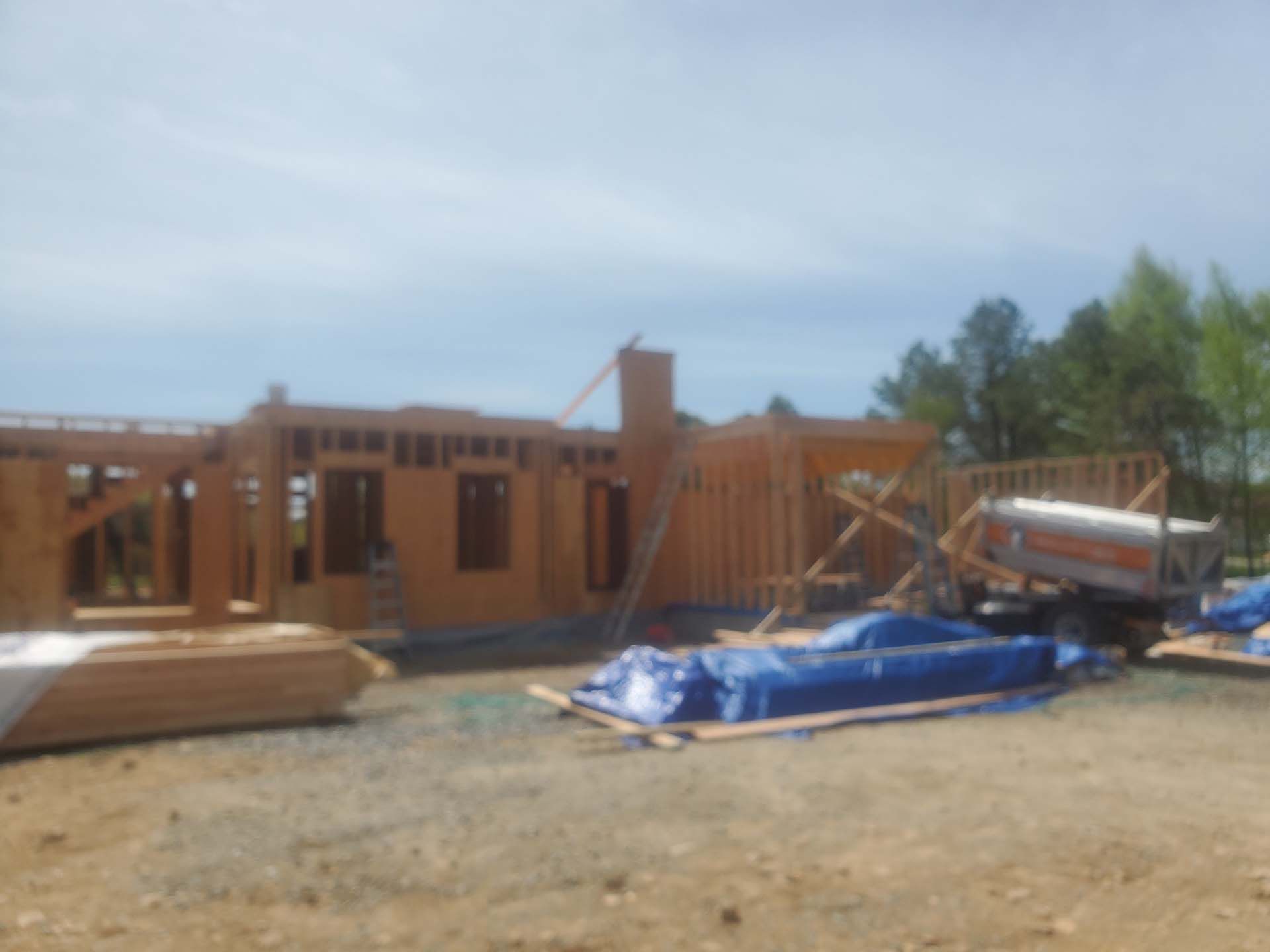 A house is being built in the middle of a dirt field.