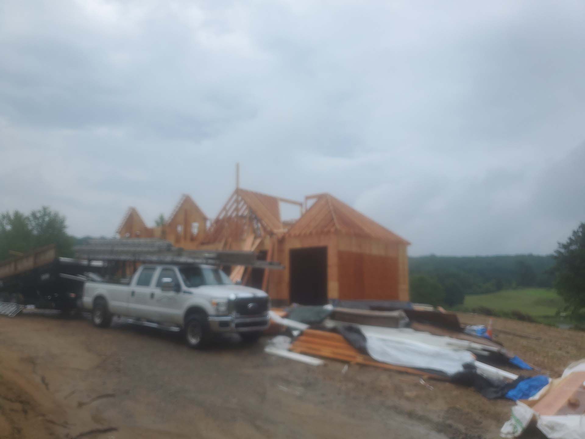 A white truck is parked in front of a house under construction
