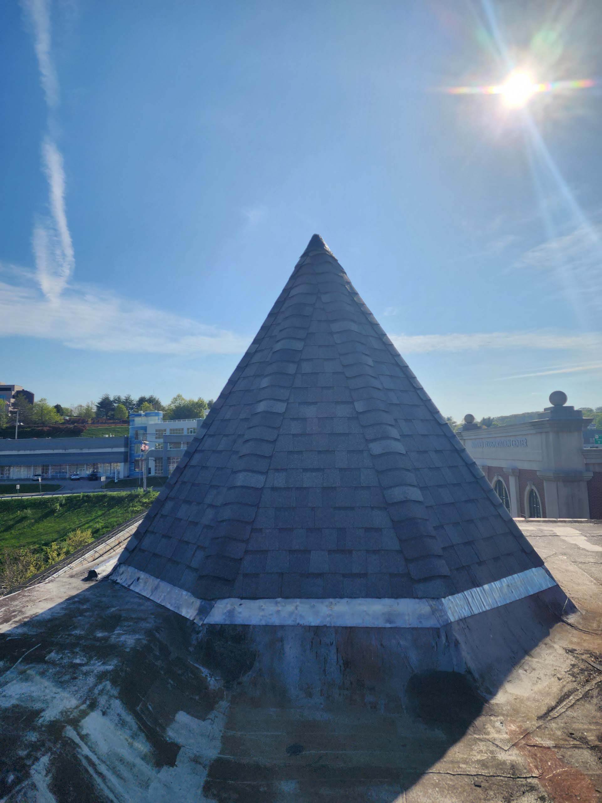 A large pyramid shaped roof with a blue sky in the background.