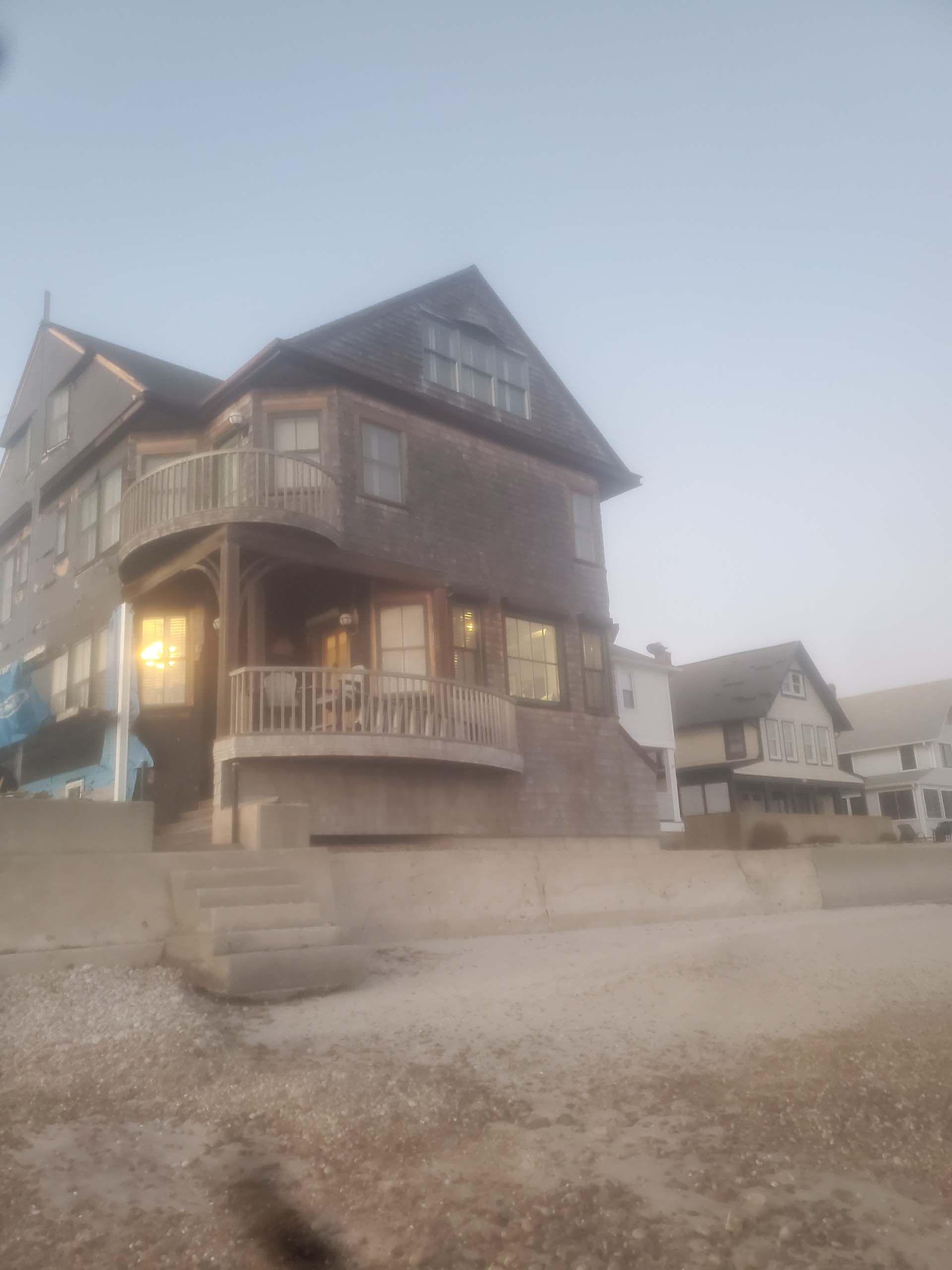 A large house with a balcony is sitting on top of a hill.