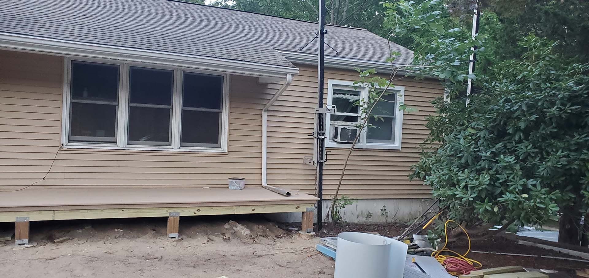 A house with a wooden deck and a gray roof