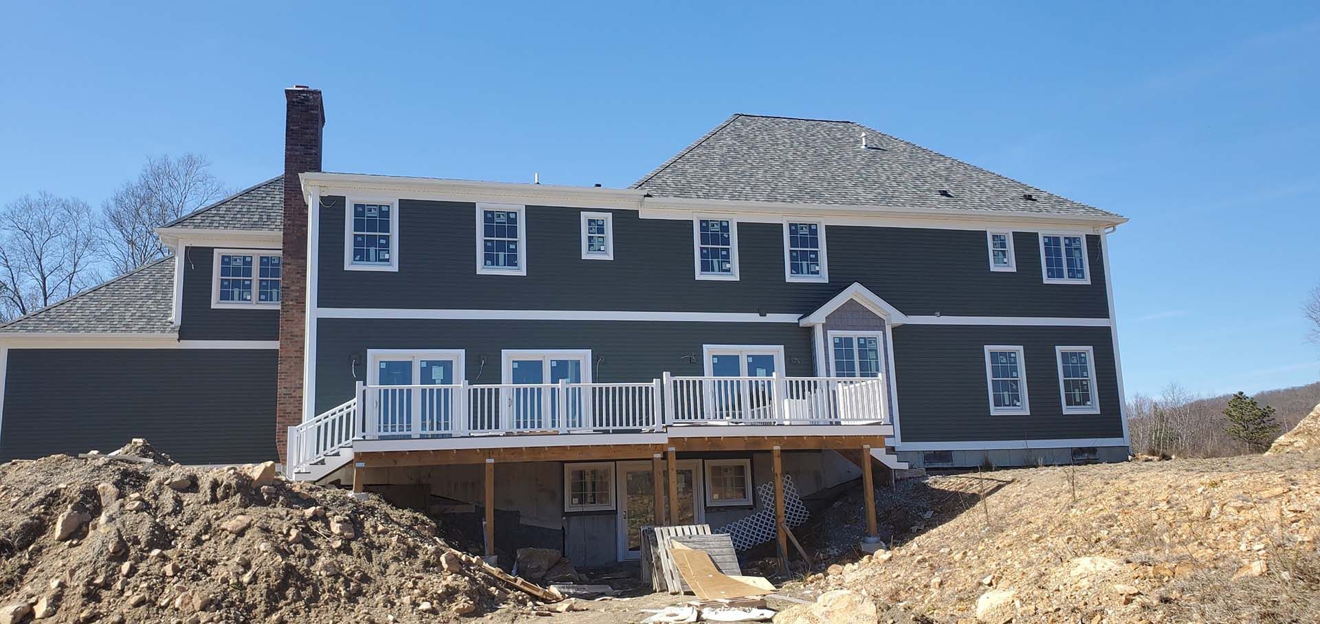 A large house under construction with a large pile of dirt in front of it