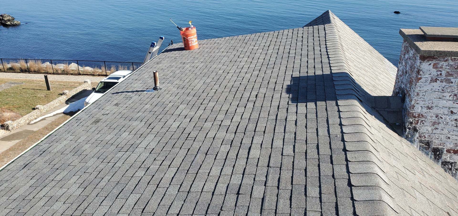 A roof with a chimney on top of it overlooking the ocean.