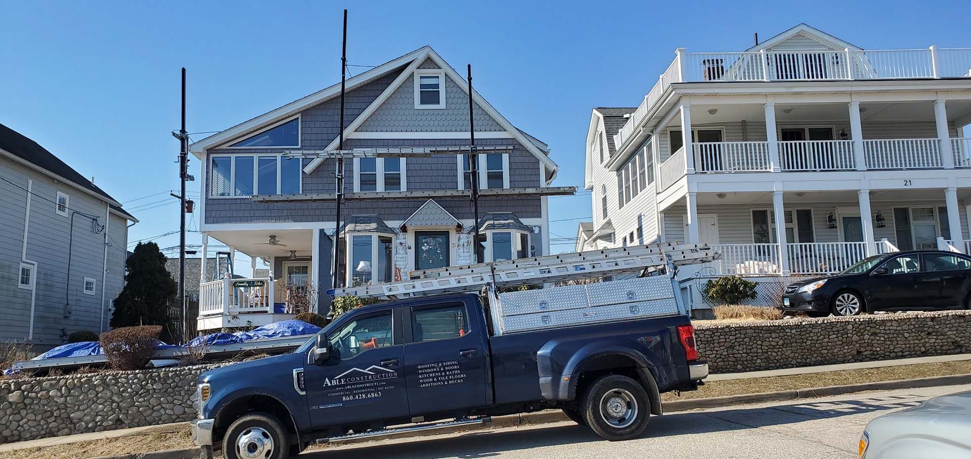 A blue truck is parked in front of a house.