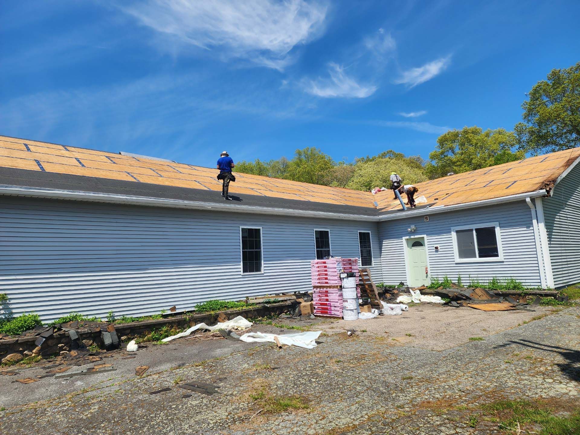 A group of people are working on the roof of a house.