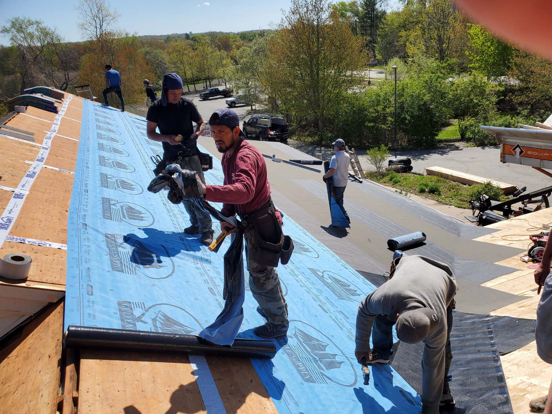 A group of men are working on a roof.