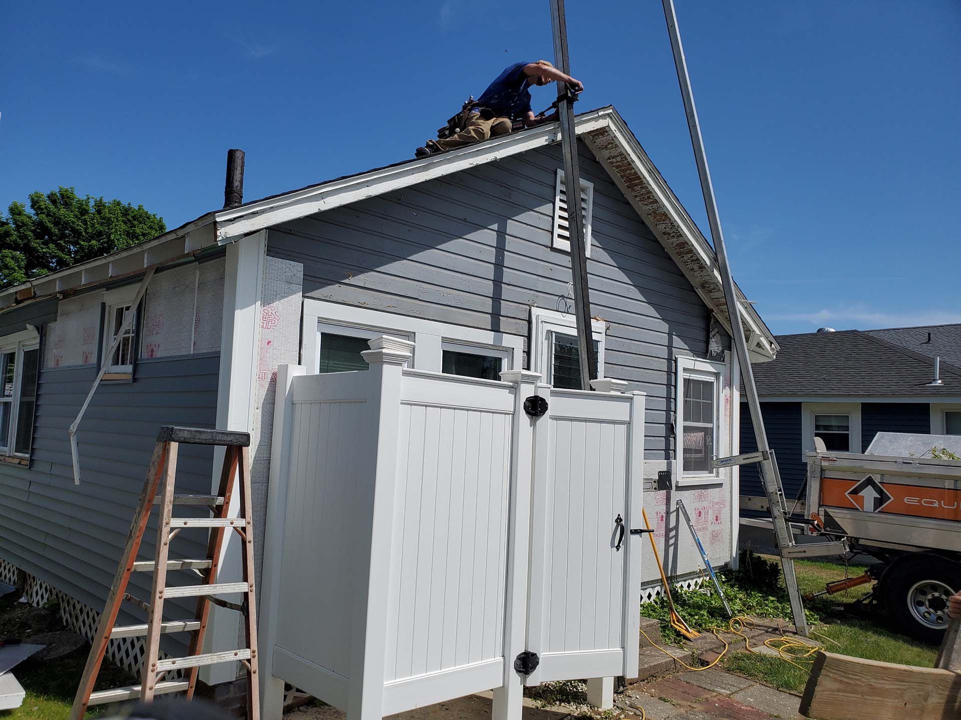 A man is working on the roof of a house.
