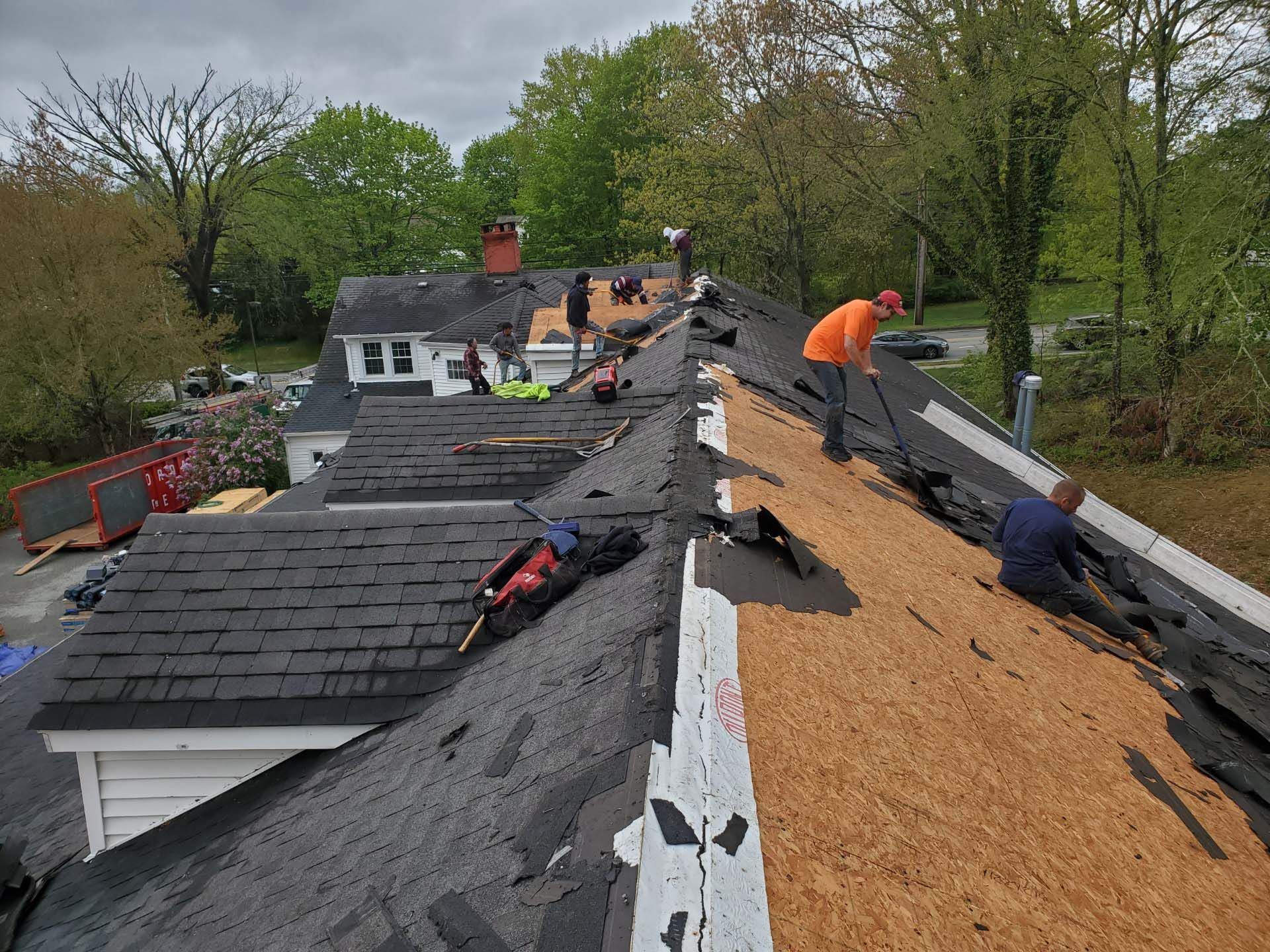 A group of men are working on the roof of a house.