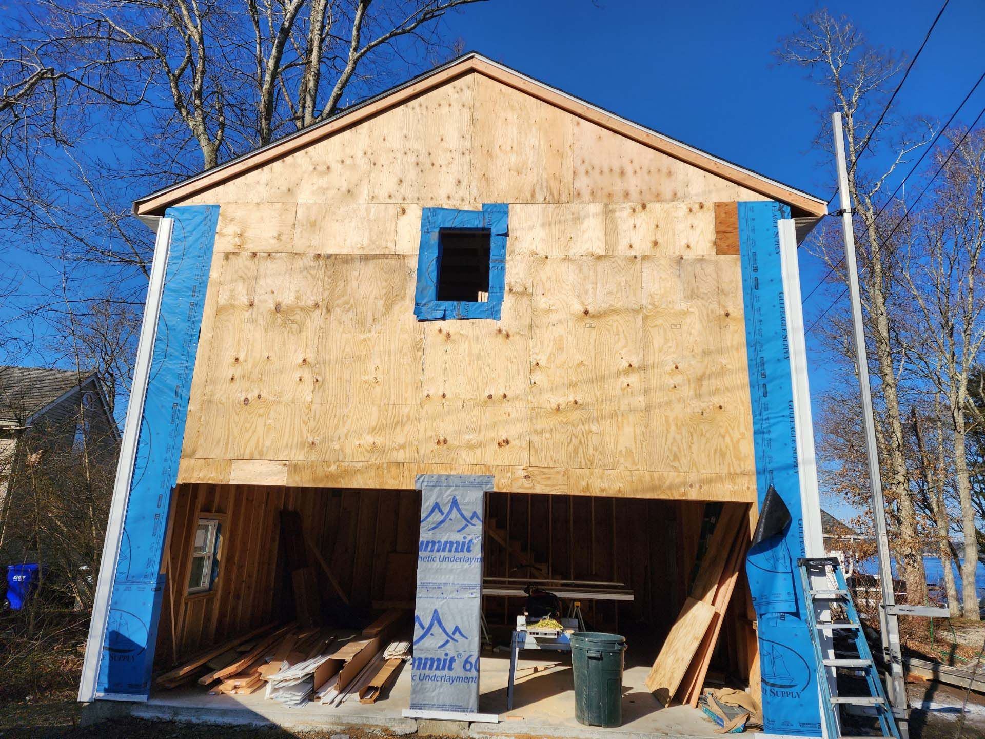 A garage is being built with plywood and a window.