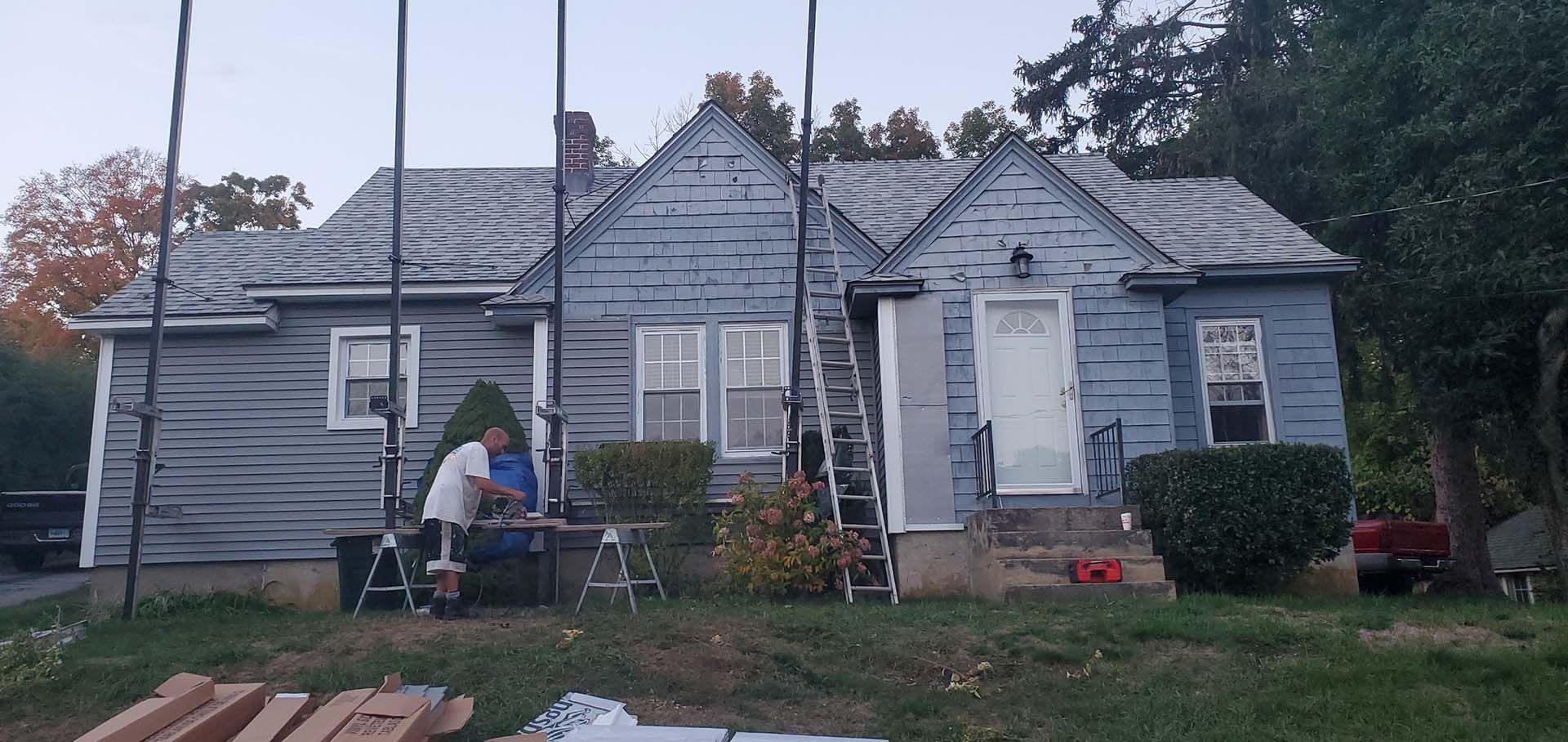 A group of people are working on the roof of a house.