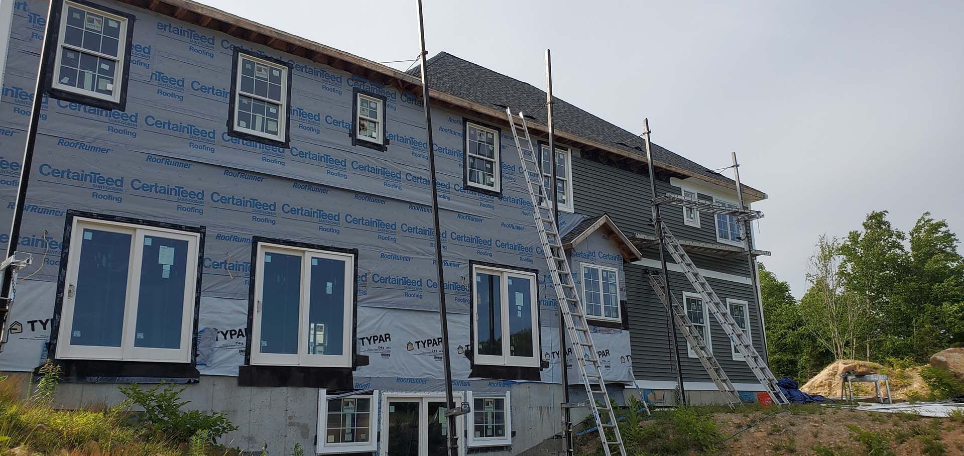 A large house with a lot of windows is being built.