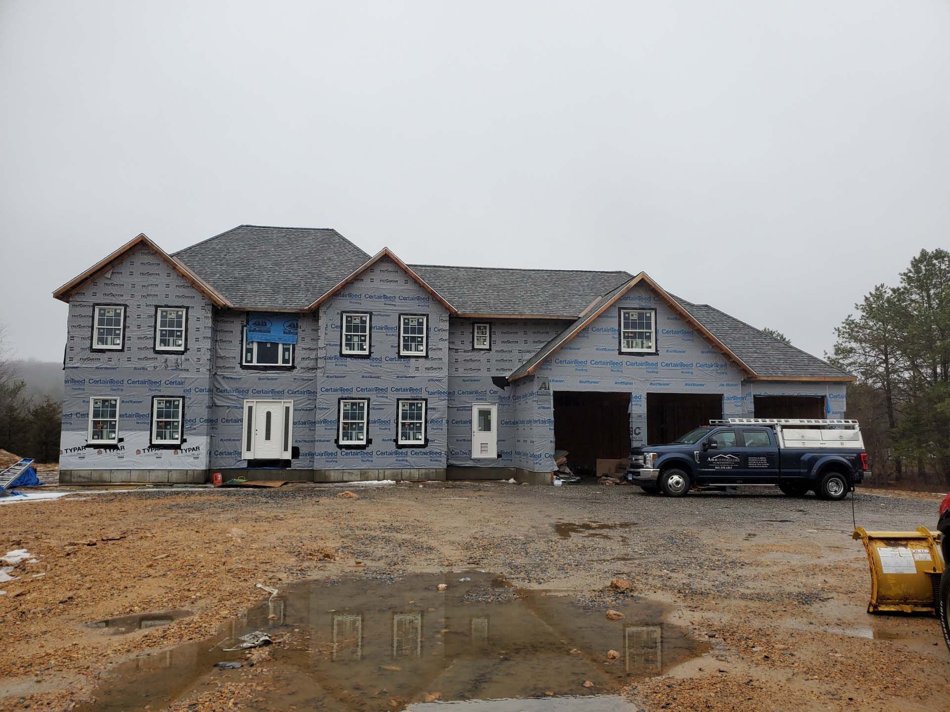 A large house under construction with a truck parked in front of it