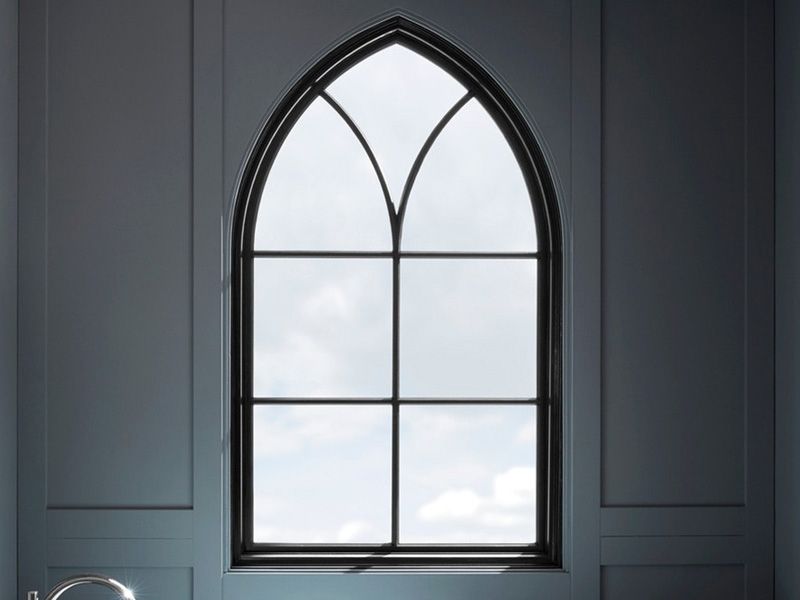 A bathroom with a large arched window and a sink.