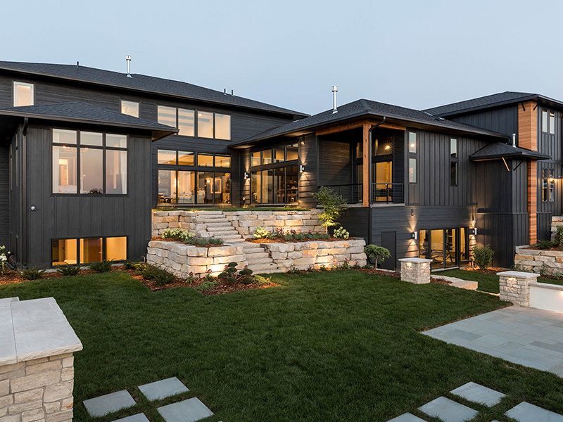 A large house with a lot of windows and a large lawn in front of it.