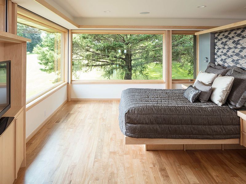 A bedroom with a large bed and lots of windows