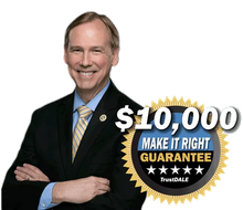 Man in suit with crossed arms, smiling, next to 